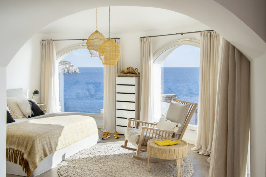 Interno di una camera da letto di design con luminose finestre vista mare di una villa di design Moretti More.