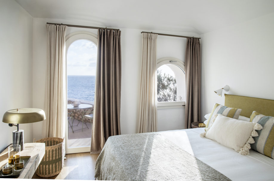 Interno di una camera da letto di design con ampia e luminosa finestra con vista mare di una villa di lusso Moretti More.